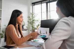 dos hembra contadores tener un equipo reunión a resumir financiero información en el oficina foto