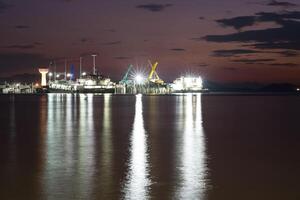 petróleo refinería industria reflexión en agua debajo nublado cielo foto