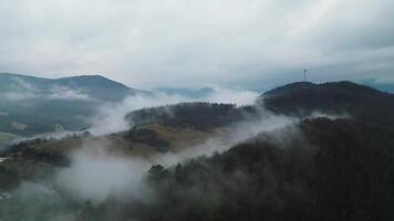 Aerial side view of foggy and cloudy hills and radio tower in Slovakia video