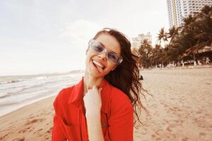 Smiling Woman Enjoying Vibrant Sunset at Beach, Feeling Carefree and Happy photo