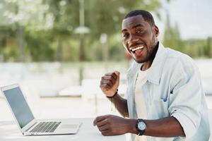 sonrisa hombre trabajo persona joven empresario negocio negro tecnología ordenador portátil en línea chico contento computadora foto