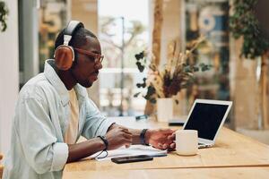 Person internet technology working businessman music male men headphones sitting laptop indoor photo