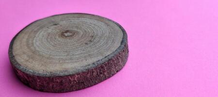 Wooden cut board on a pink background. Selective focus. photo