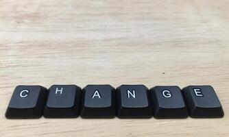 The word change written with black computer keyboard keys on wooden background. photo