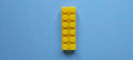 Plastic building blocks on a blue background. Minimal concept. photo