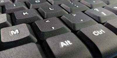 Close up of a black computer keyboard on a blue background with copy space photo