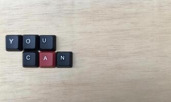 The word you can written with black cubes on a wooden background photo