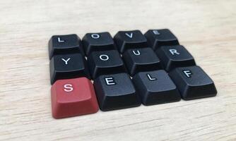 amor tú mismo palabra en negro teclado botón en madera fondo, amor tú mismo concepto foto