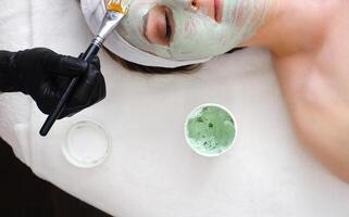 Applying Facial Mask with Brush in Beauty Treatment photo