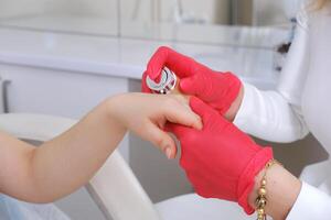 Cosmetologist Applying Cream on Client's Hand photo