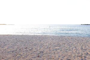 Beautiful sandy beach and sea in the evening light, summer background photo