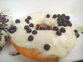 assorted donuts with chocolate frosted, pink glazed and sprinkles donuts. photo