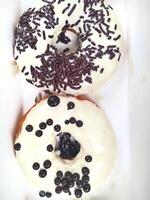 assorted donuts with chocolate frosted, pink glazed and sprinkles donuts. photo
