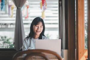 Business freelance concept, A joyful woman with braces smiles while working on her laptop in the warm ambiance of a sunny cafe interior. photo