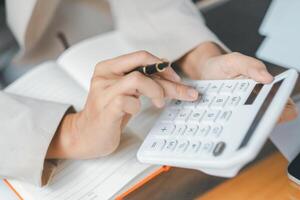 Close up, Businesswoman using calculator and laptop at a sunny cafe, a perfect blend of technology and productivity. photo