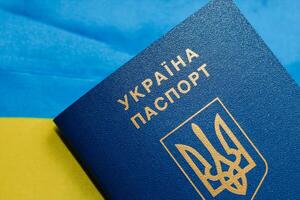 Ukrainian passport with the flag of Ukraine on a wooden table. photo