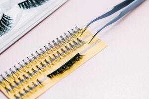 Artificial false fluffy eyelashes with tweezers. photo