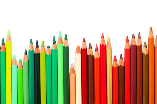 Multi-colored pencils lie on a white table, the green range of colors photo