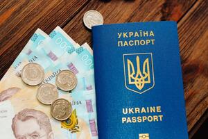 Ukrainian hryvnia money on the table and a Ukrainian passport. photo