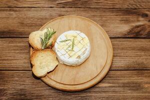 White baguette cut into pieces with olive oil and Camembert cheese on the table. photo