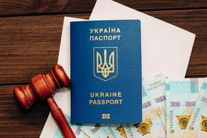 Ukrainian hryvnia money on the table with documents with a place for text and a passport to Ukraine. photo