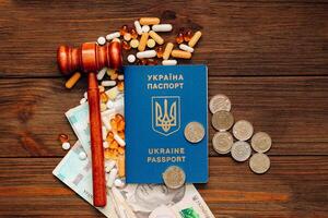 Ukrainian hryvnia money and pills on the table and a Ukrainian passport. photo