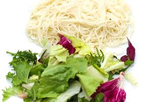 Thin wheat Asian noodles close-up with salad photo