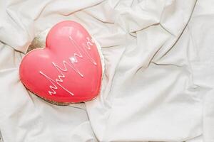 Heart shaped pink mousse cake on the table. photo