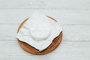 Camembert cheese unwrapped from packaging on the table. photo