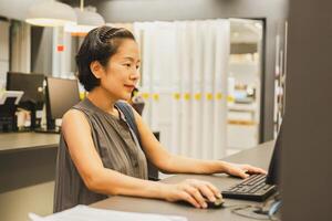 Beautiful woman using computer in coworking space. photo