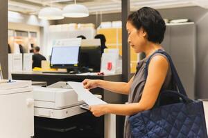 Businesswoman prints on the printer in the office. photo