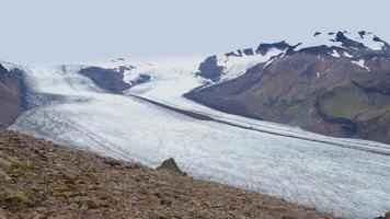 un' donna viaggi nel il montagne di Islanda. il skaftafellsjokull ghiacciaio nel il sfondo. skaftafell nazionale parco. Islanda. 4k video