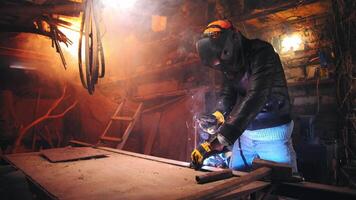 Dramatic shot of a man welding in an old garage, working with steel, close-up of a work place, welding as a hobby video