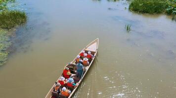 bateaux avec gens touristes dans la vie vestes flotte sur une champ avec lotus dans été. personnes âgées tourisme aérien voir. vidéo de drone. video