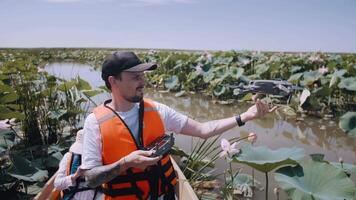 een Mens lanceert een Copter in de lucht terwijl zittend in een boot Aan de rivier. video