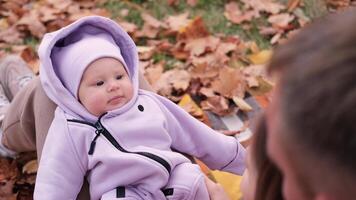 jung Eltern auf ein gehen mit ein Baby im das Herbst Park. Nahansicht von ein Kinder Gesicht video