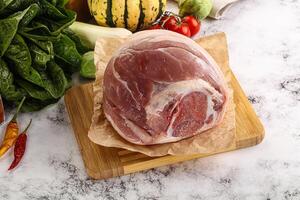 Uncooked raw pork knuckle with spices photo