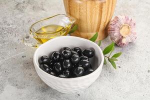 Black olives with oil and branch photo