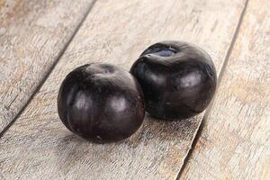 Two ripe sweet black plums photo