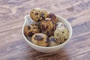 Raw quail eggs heap in the bowl photo