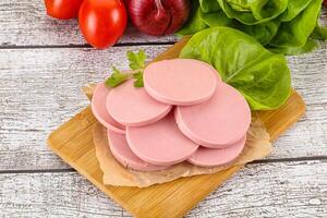 Slices boiled sausages for breakfast photo