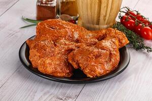 Raw turkey shoulder wing in Indian tandoori marinade photo