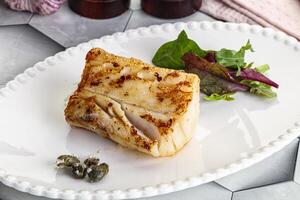 Roasted cod fish steak with salad photo