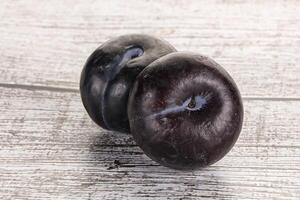 Two ripe sweet black plums photo