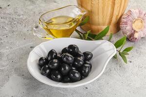 Black olives with oil and branch photo