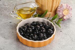 Black olives with oil and branch photo