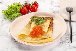 Russian pancake with red caviar photo