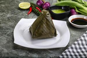 Asian cuisine - rice with filling in banana leaf photo