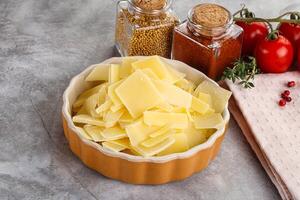 Sliced parmesan cheese in the bowl photo