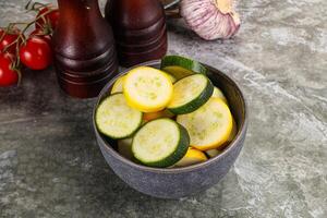 Sliced raw young green and yellow zucchini photo